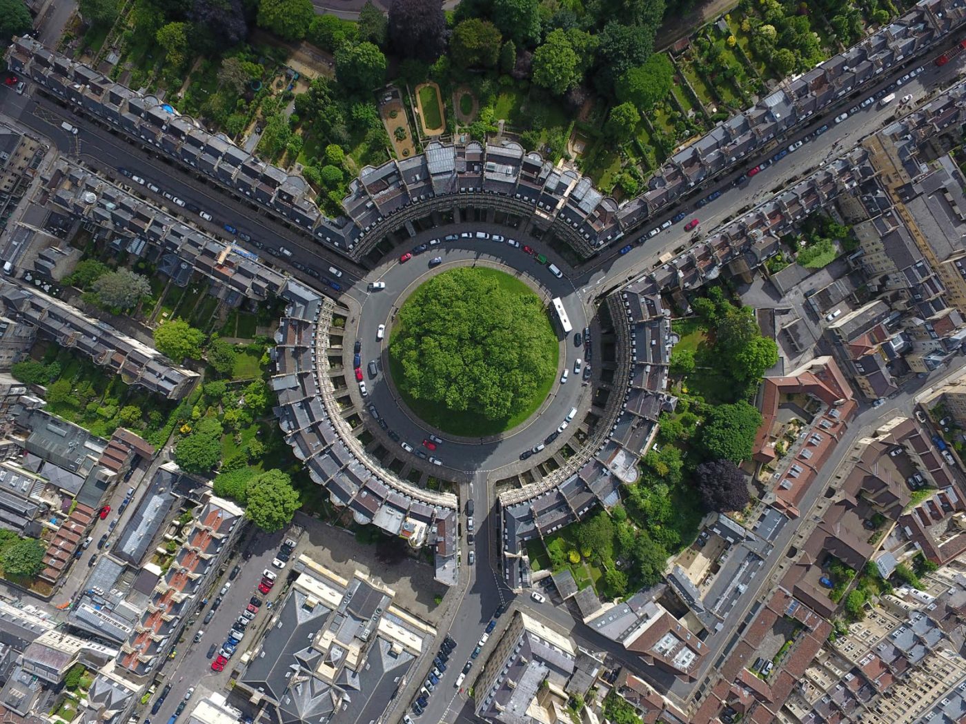 Aerial view of Bath, UK, showing circular buildings and surrounding streets.