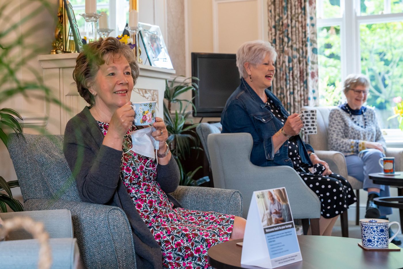 Two ladies sitting down having a cup of tea.