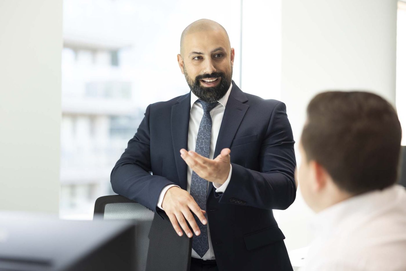 Businessman in suit discussing work with a colleague.