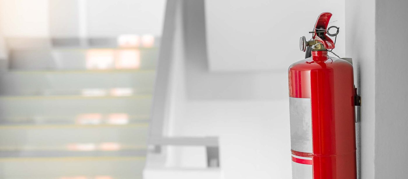 Red fire extinguisher mounted on a wall.