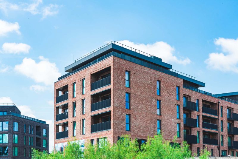 Modern brick apartment building with balconies.