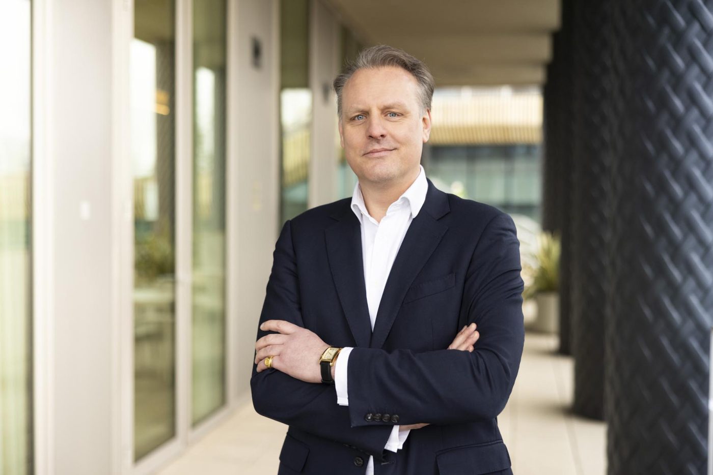Portrait of a man in a suit, arms crossed.