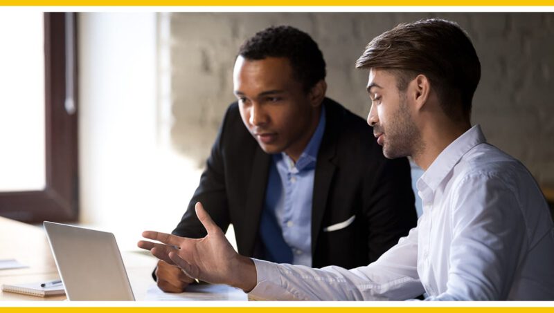 Two colleagues collaborating at a laptop.