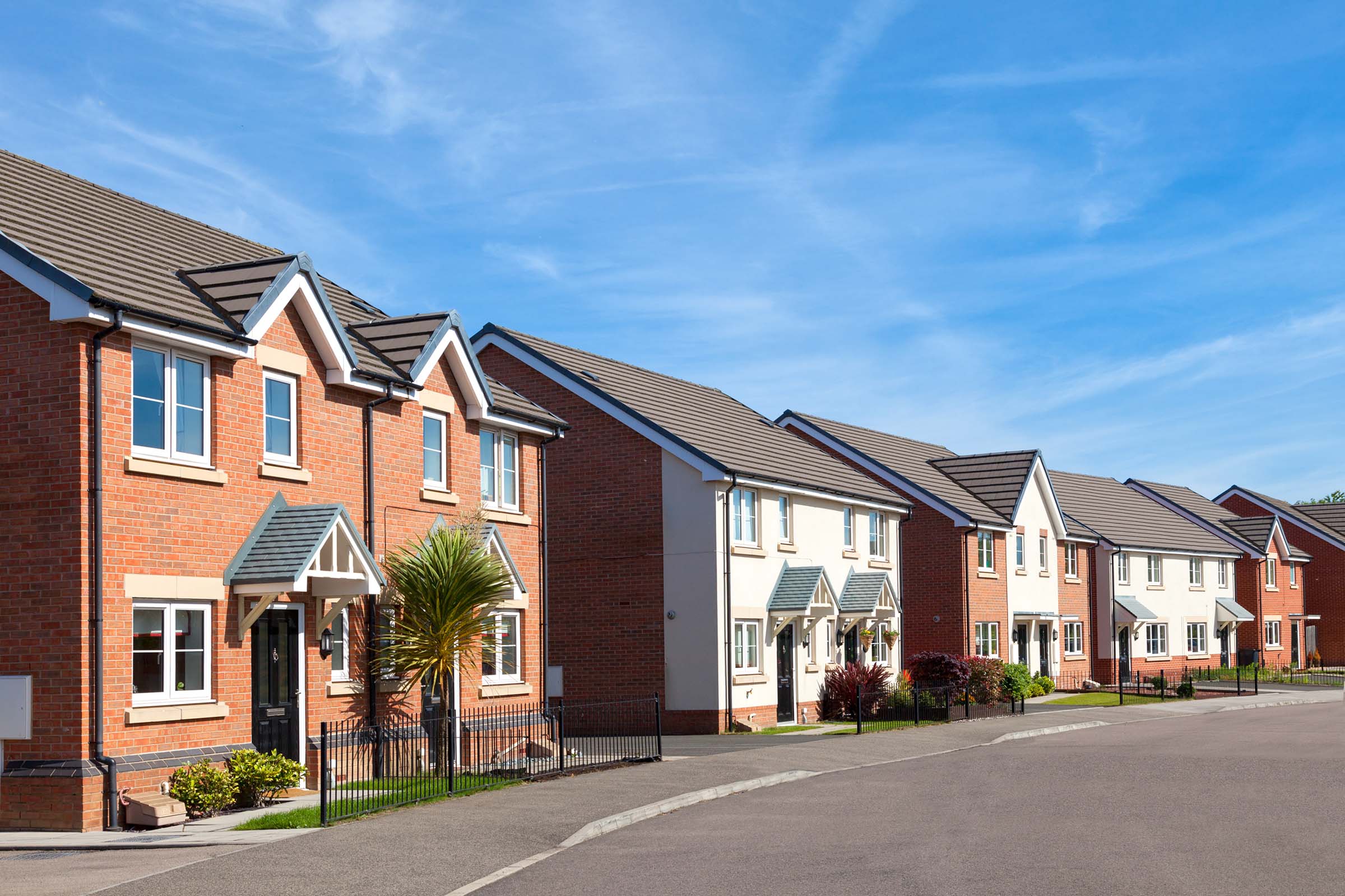 Row of brick houses on a sunny street.
