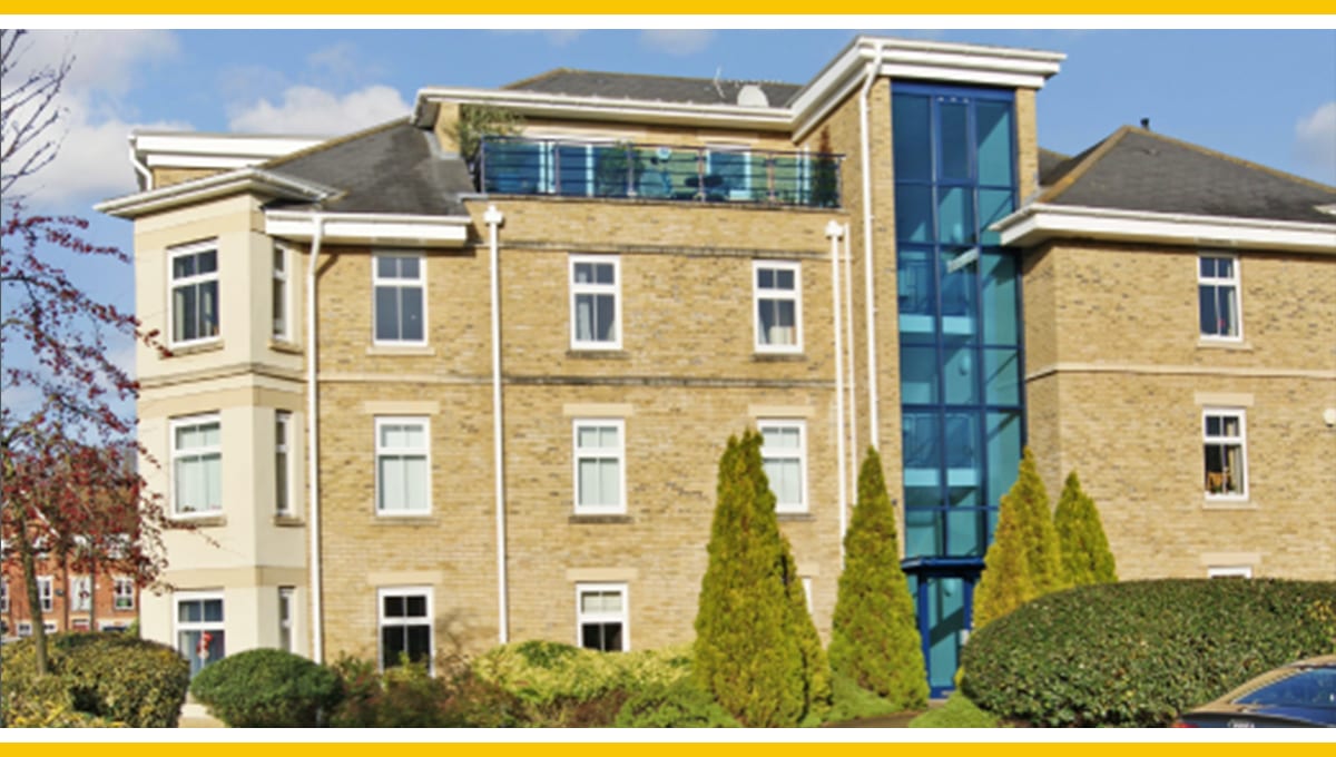 The Waterways building exterior; tan brick apartment building with glass elevator.