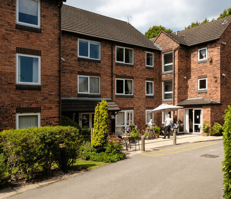 Brick building with residents outside; ARHM accreditation.