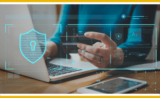 Person using laptop and credit card;  cybersecurity shield graphic overlay.