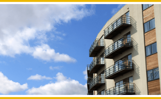 Apartment building with balconies against a blue sky.
