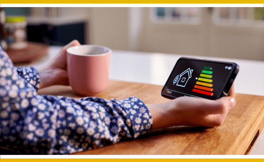 Person holding smartphone showing home energy efficiency rating.