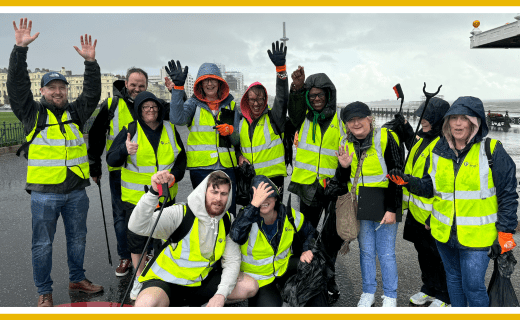 Group of volunteers in hi-vis vests participating in a beach clean.