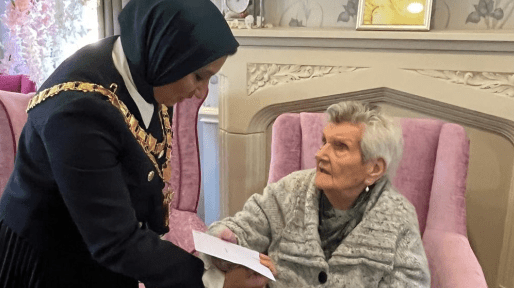 The Mayor of Solihull presents a card to a resident.
