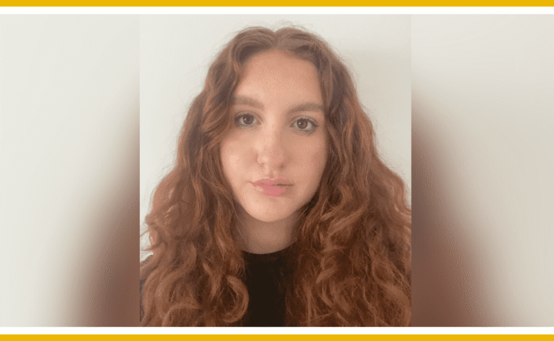 Portrait of a young woman with long, curly auburn hair.