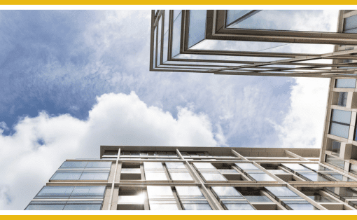 Modern building viewed from below against a partly cloudy sky.