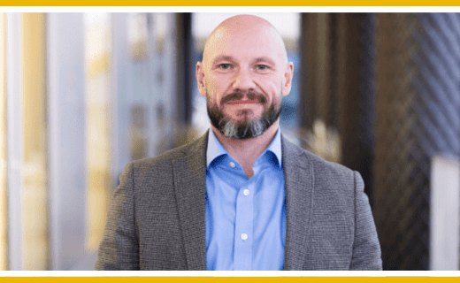 Portrait of a middle-aged man in a gray blazer.