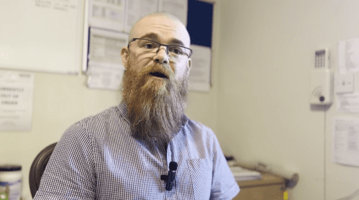 Veteran employee speaking in office setting.